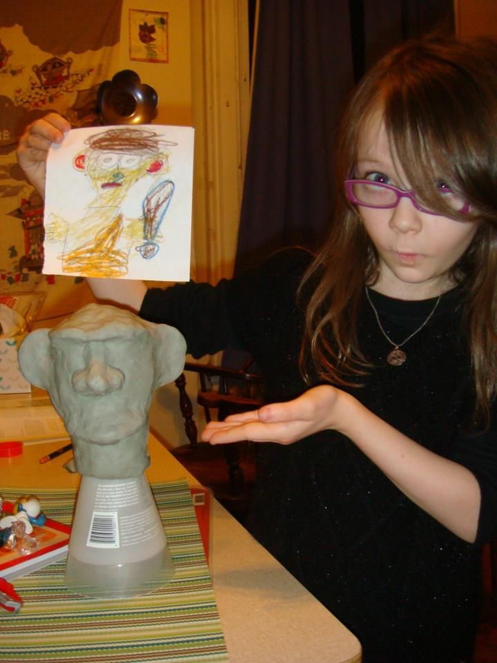 Eleanor with her concept sketch and the sculpted head of Unka Unka the Caveman.